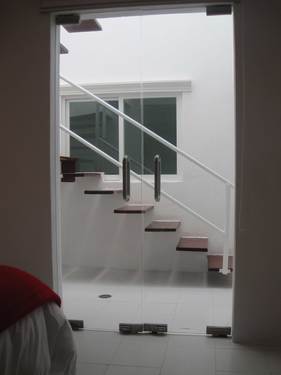 View to stairwell from ground floor guest bedroom with queen size bed